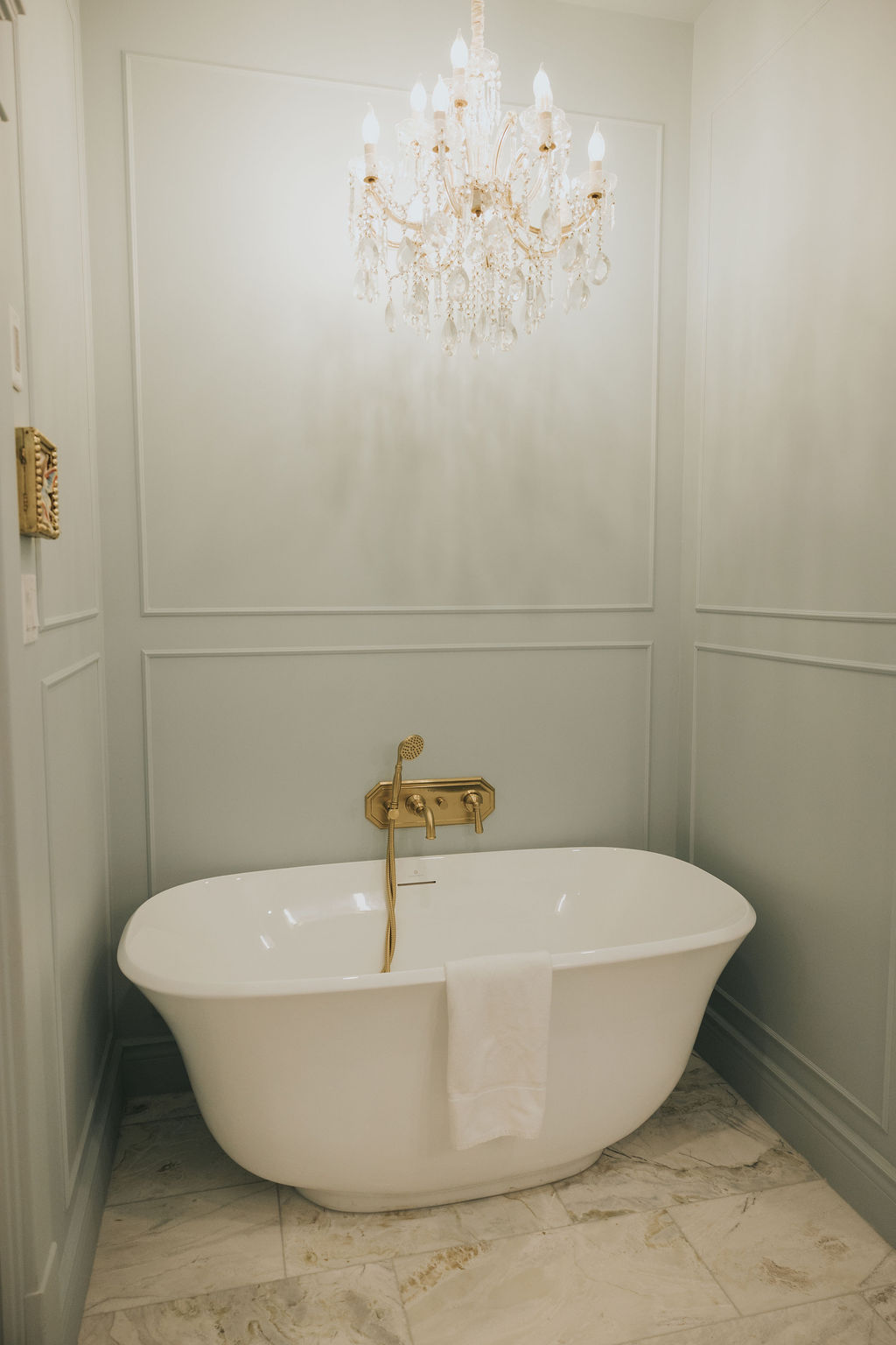 Baignoire blanche sous un lustre en cristal