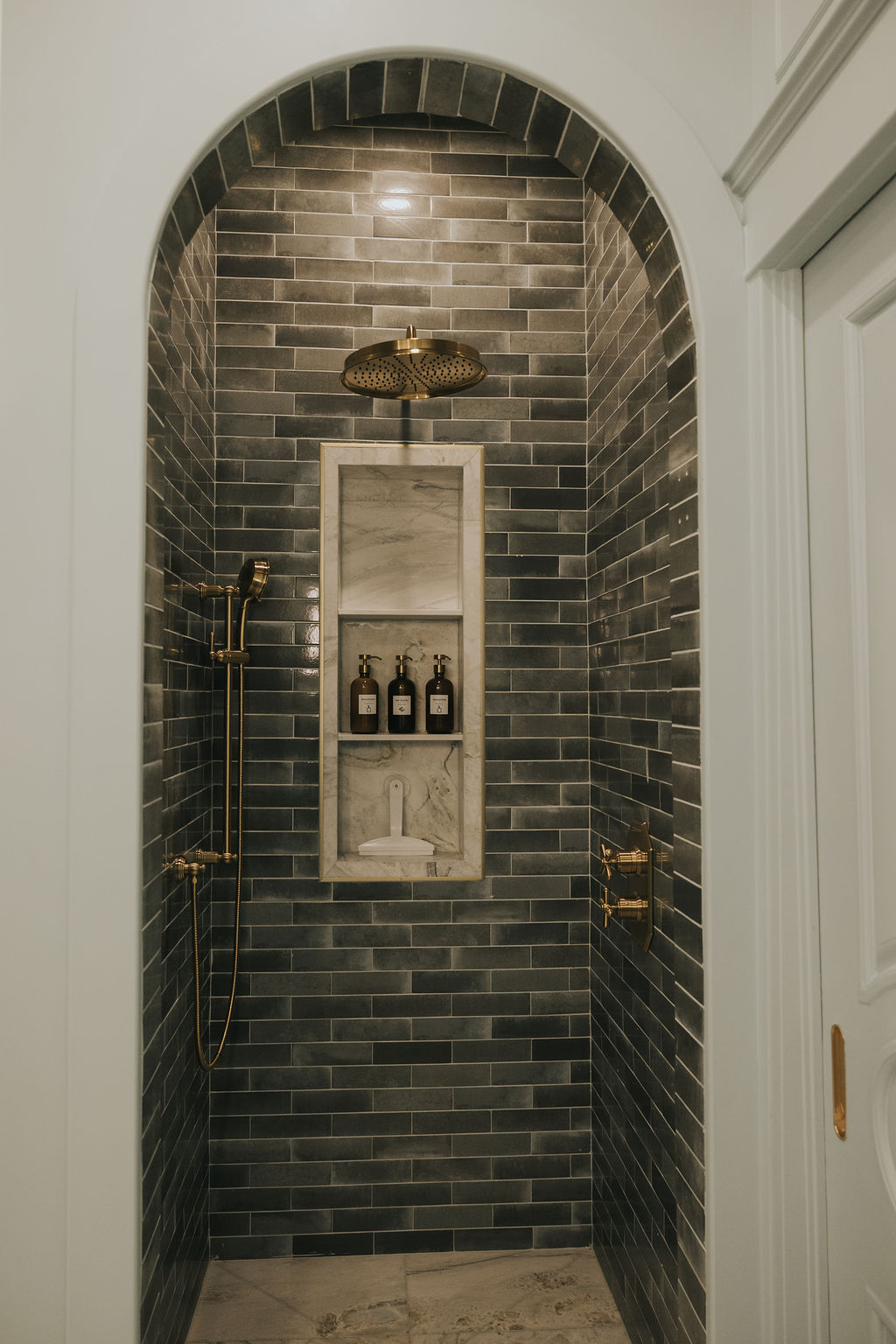Douche voûtée en carreaux noirs et laiton